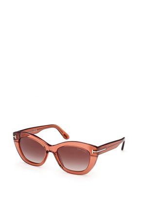 Occhiali da sole color marrone con forma a gatto, montatura trasparente marrone e eleganti rifiniture in metallo sulle astine. Gradazione delle lenti da chiaro a scuro.