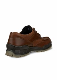 Bruine leren schoen met een gestructureerde zwarte rubberen zool, voorzien van een ronde neus, vetersluiting en een gevoerde kraag voor comfort.