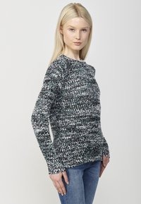 Pulover tricotat texturat în gri închis, gri deschis și teal. Gât rotund și mâneci lungi, ajustat la talie, cu un aspect moale și confortabil.