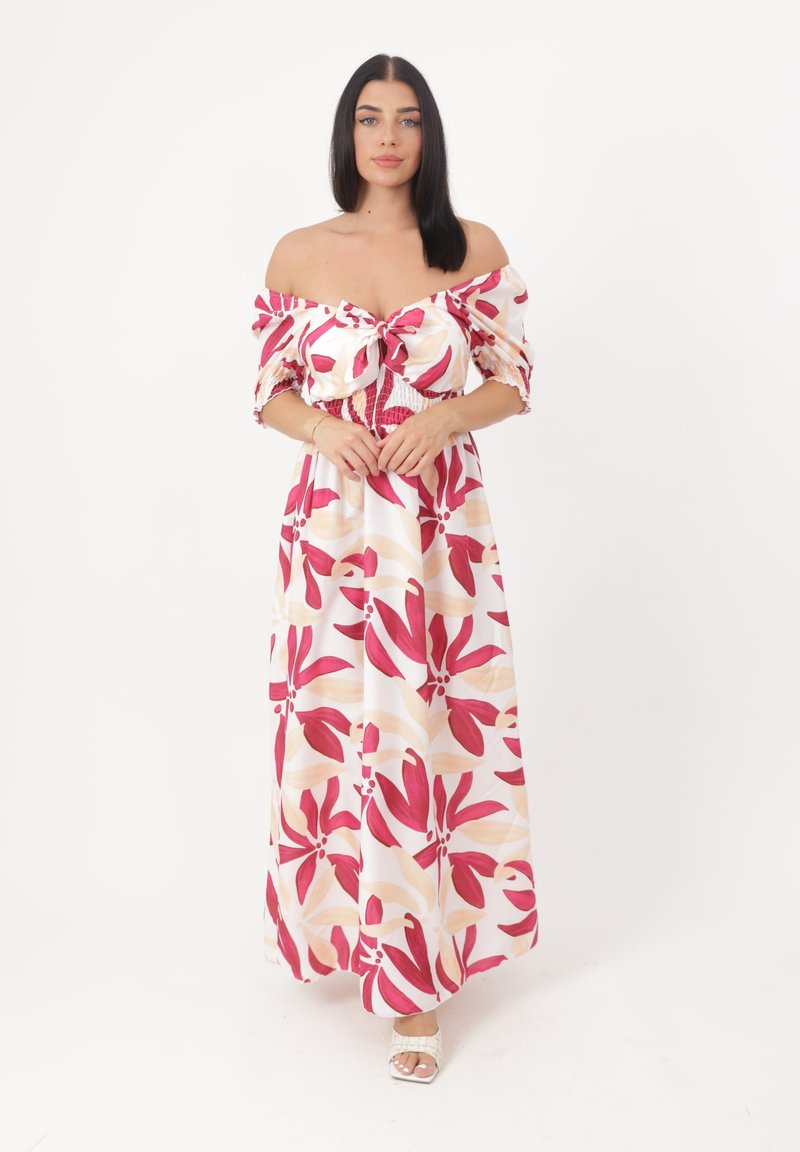 Robe maxi avec un design à épaules dénudées, présentant des motifs floraux roses et beiges sur un fond blanc, et un corsage froncé.