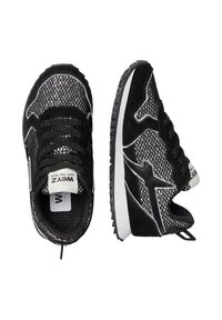 Scarpe sportive in mesh nere e argento con suole bianche, una mostrata dall'alto e l'altra di profilo, con un motivo a stella sul lato.