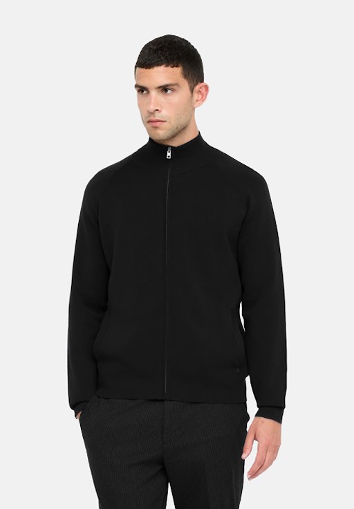 Giacca nera con zip realizzata in tessuto morbido, caratterizzata da un colletto alto e maniche lunghe. Texture liscia con un design minimalista e senza motivi visibili.