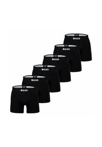 Svarta boxershorts i rad, med en vit logotyp på den elastiska midjebandet. Slät tyg, figurnära design.