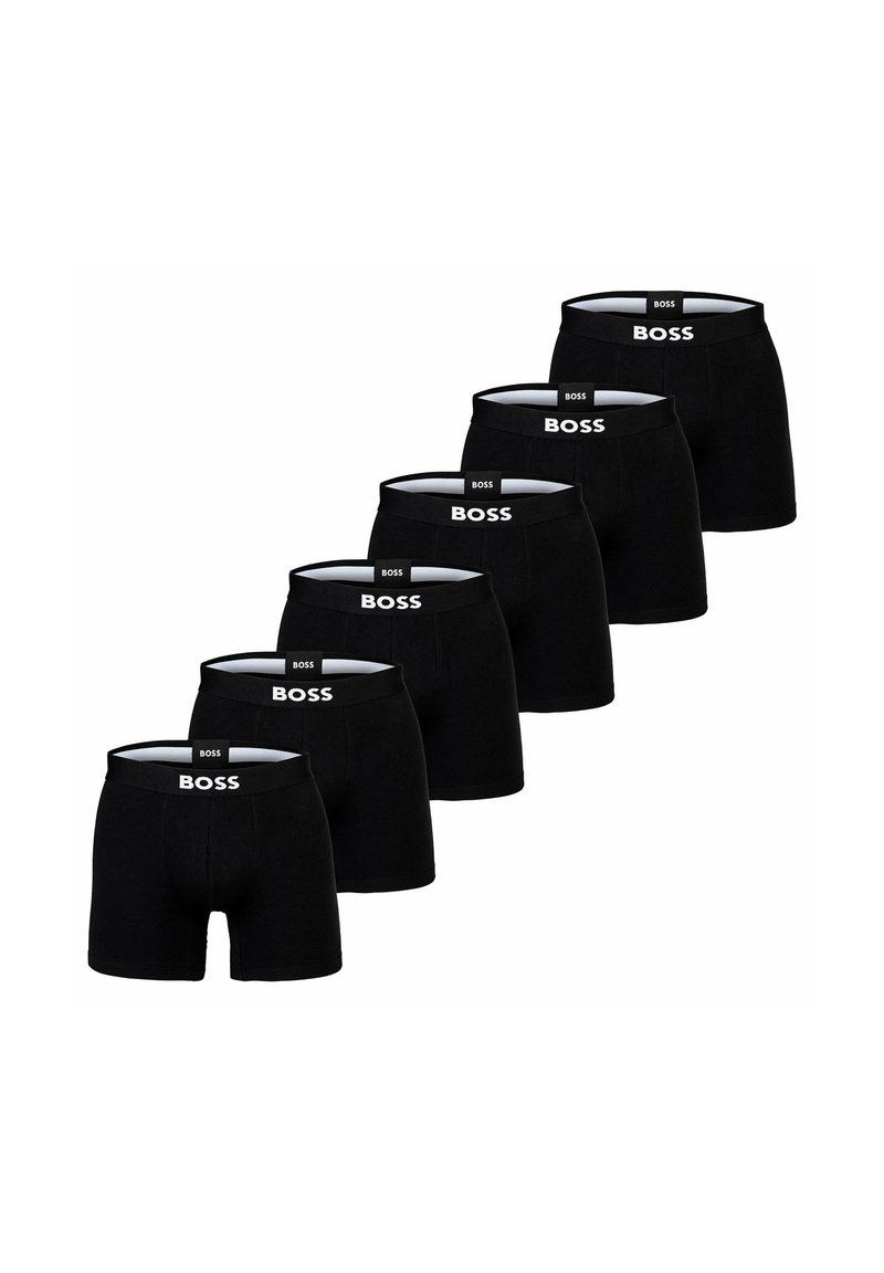 Svarta boxershorts i rad, med en vit logotyp på den elastiska midjebandet. Slät tyg, figurnära design.