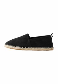 Crne espadrile slip-on cipele s teksturiranim gornjim dijelom od tkanine, jute užad u đonu i kontrasnim šavovima duž ruba. Minimalistički dizajn.