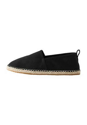 Crne espadrile slip-on cipele s teksturiranim gornjim dijelom od tkanine, jute užad u đonu i kontrasnim šavovima duž ruba. Minimalistički dizajn.