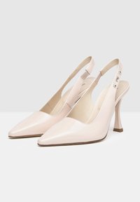 Decolletè slingback in pelle verniciata beige con punta affusolata, fascia elastica e tacco affusolato da 5 cm; presenta dettagli metallici sulla fascia.