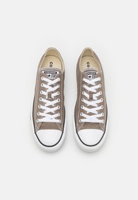 Baskets en toile marron avec des semelles en caoutchouc blanc et des lacets. Présente un accent noir sur l'embout et un logo d'étoile sur la languette. Taille 8.