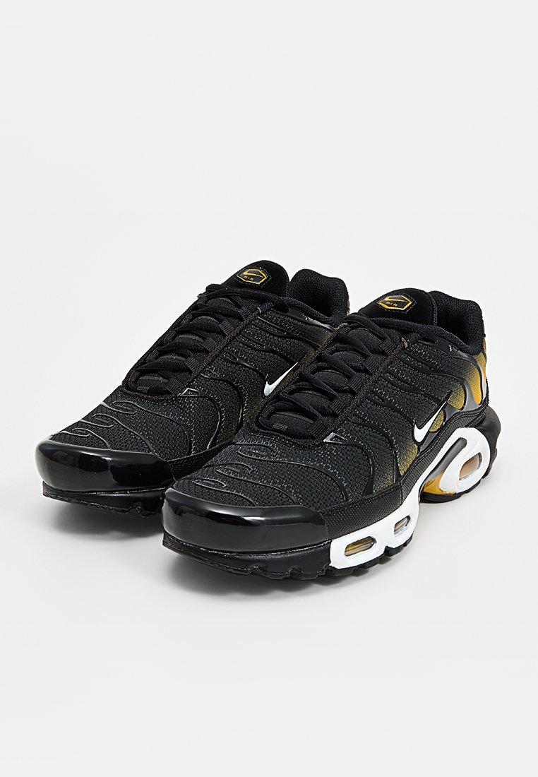 Schwarze Sneaker mit einem texturierten Mesh-Obermaterial, glänzenden schwarzen Akzenten und kontrastierenden Details in Weiß und Gold bei der Luftpolsterung. Schnürdesign.