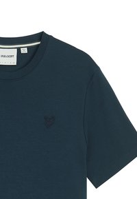Mørkeblå bomulds T-shirt med rund hals, korte ærmer og et lille, broderet sommerfuglelogo på venstre bryst.