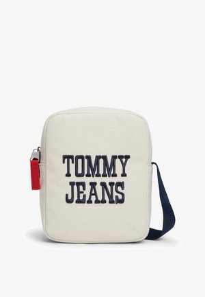 Lille rektangulær hvid skuldertaske med navy blå rem og "TOMMY JEANS" broderet i sort på forsiden.