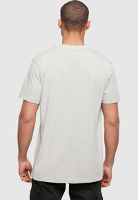 Light gray short-sleeve t-shirt made from soft cotton with a round neckline and a relaxed fit, viewed from the back. No visible patterns or graphics.