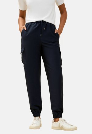 Pantaloni jogger blu navy in un tessuto morbido e liscio, con vita elastica, tasche laterali e polsini elastici alle caviglie.
