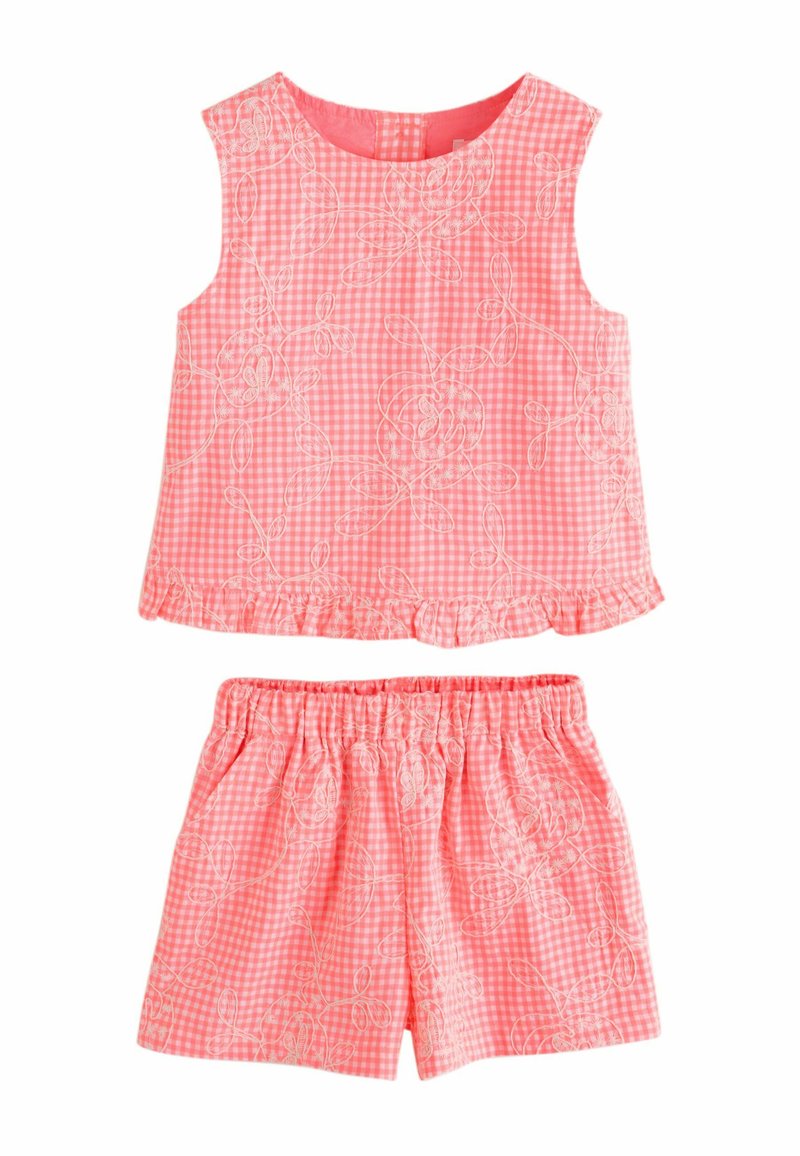 Ærmeløst pink gingham-top og shorts med elastisk talje, hvid blomsterbroderi og flæsekanter nederst på toppen.