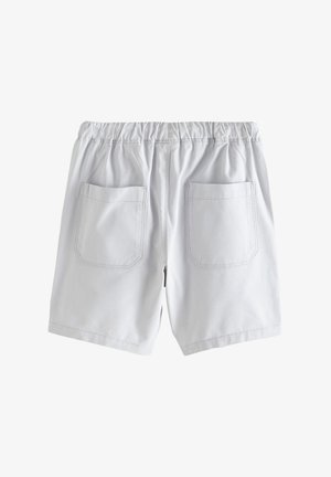 Fehér elasztikus derékpántú rövidnadrág két hátsó zsebfedővel és látható varrással, egyszínű fehér háttér előtt.