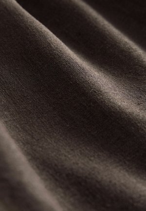 Dunkelbrauner Stoff mit einer glatten, strukturierten Oberfläche, der subtile Falten und ein weiches, mattes Finish aufweist. Ideal für verschiedene textile Anwendungen.