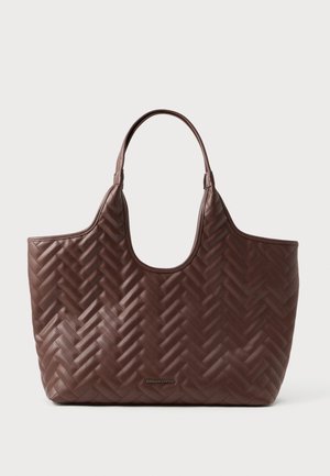 Grand sac fourre-tout en cuir matelassé marron avec des poignées doubles et un motif en chevrons, présenté sur un fond blanc uni.
