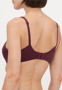 Maroons bh med justerbare stropper, en glatt tekstur, og et sikkert lås bak. Enkel design uten utsmykninger.