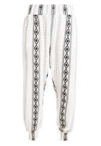 Bílé volné kalhoty s černými geometrickými vertikálními pruhy, elastickým pasem a nařasenými manžetami na kotnících.