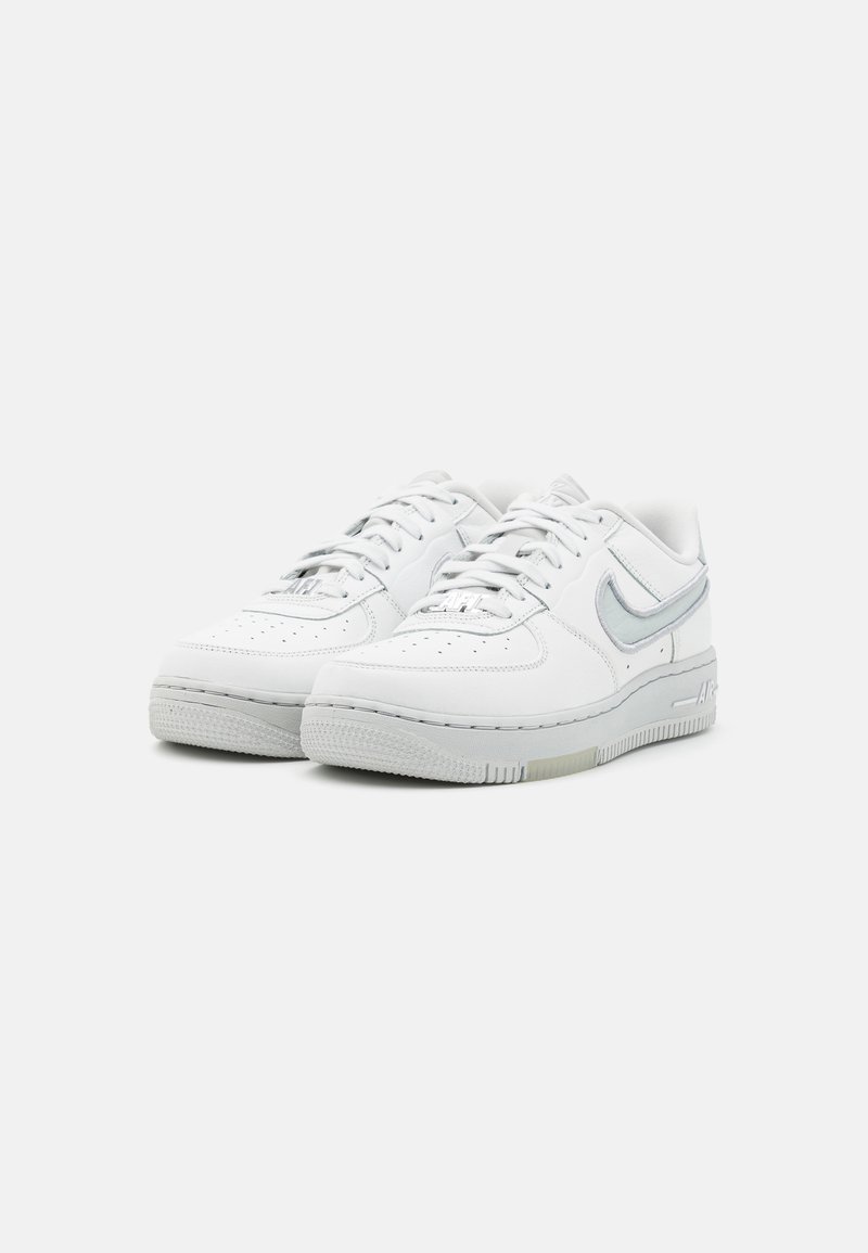 Weiße Sportsneaker mit einem glatten Lederobermaterial, perforiertem Zehenbereich und hellgrauen Akzenten am Swoosh und der Sohle. Texturierte Gummisohle.