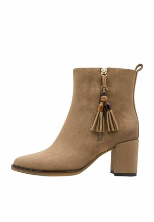 Tan suede ankle boot with block heel, side zipper, and decorative tassels with beads on the outer side.