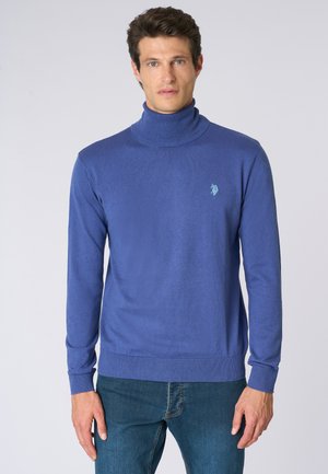 Maglione a collo alto blu in texture fine, con un piccolo logo sul petto. Il design include polsini e orlo a coste.