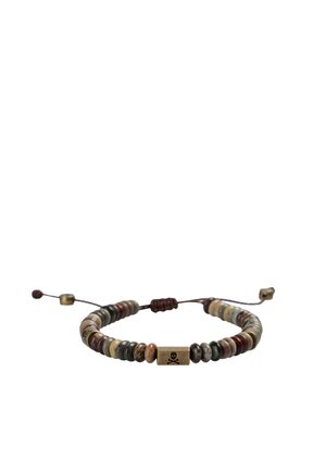 Pulsera ajustable de cuentas con piedras multicolor y una cuenta rectangular central dorada grabada con un símbolo de calavera y huesos cruzados.