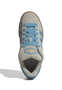 Wildledersneaker in Hellgrau mit blauen Streifen und Schnürsenkeln. Runde Zehenpartie mit einer beige Gummisohle. Enthält ein rundes, goldenes Logo auf der Zunge.