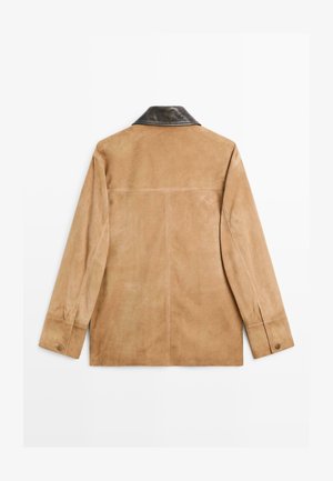 Suède jack in lichtbruin met een donkere leren kraag. Beschikt over lange mouwen en subtiele stiksels. Gladde textuur.