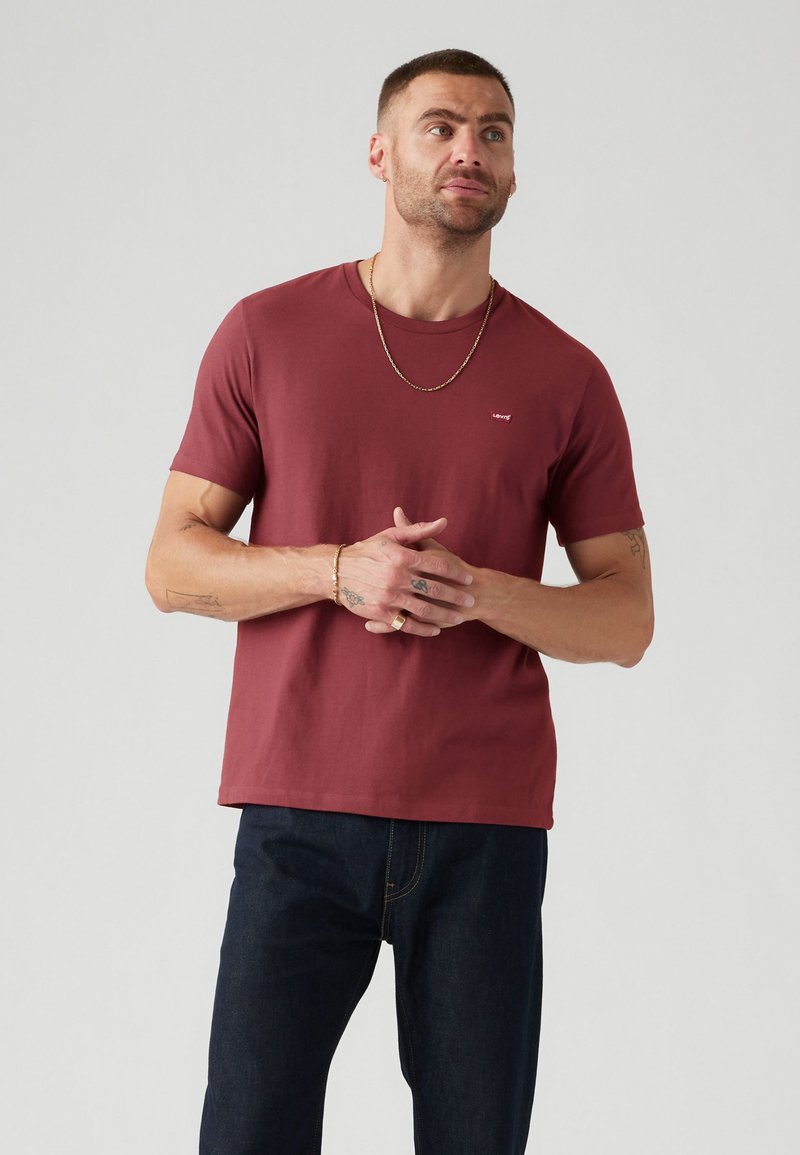 Rode crewneck t-shirt van katoen. Korte mouwen,Relaxed fit. Klein logo op de bovenste linkerkant van de borst. Gemaakt met donkerblauwe jeans.
