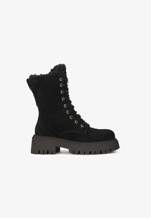 Fekete velúr, középig érő csizmák puha prémes béléssel, fűzős elülső résszel, vastag, texturált talppal és fémlakkal. Robosztus dizájn húzófüllel.