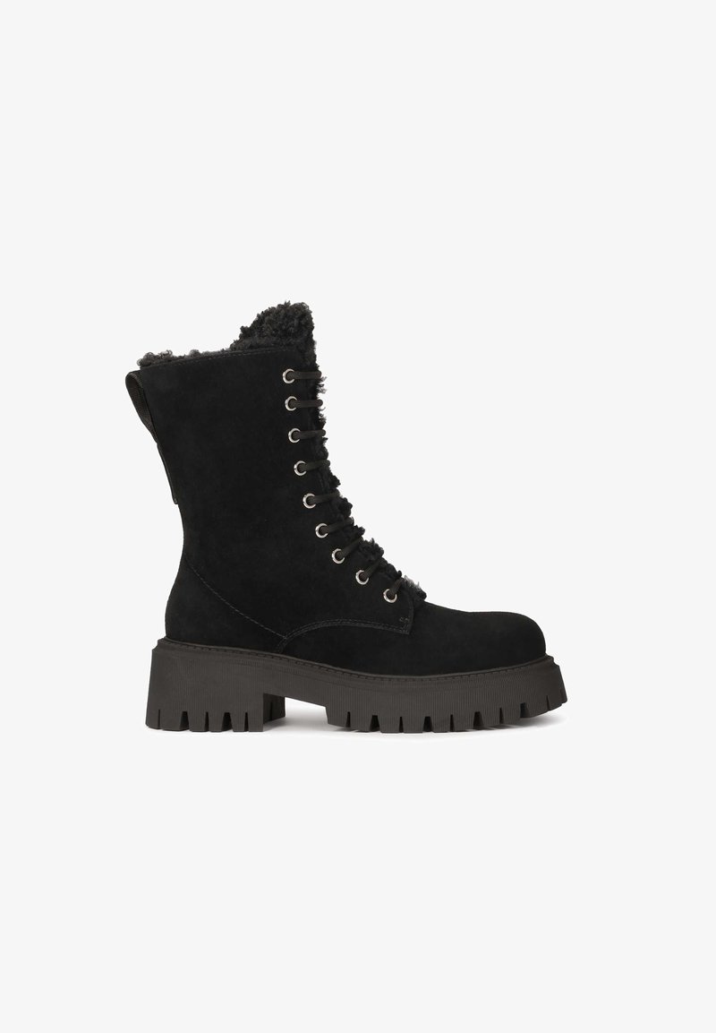 Botas de ante negro hasta la pantorrilla con un forro de piel de peluche, parte delantera con cordones, suela gruesa texturizada y ojales de metal. Diseño resistente con una lengüeta.