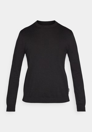 Melnā garroku džemperis ar apaļu kakla izgriezumu, izgatavots no ribotas auduma. Raksturīga pieguloša siluets un taisna apakšmala ar nelielu zīmola etiķeti sānos.