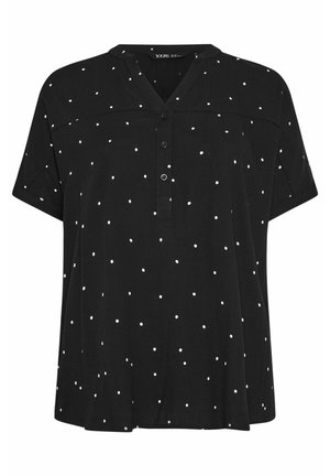 Blusa negra de manga corta con lunares blancos, escote en V con una tapeta de tres botones y un corte holgado.