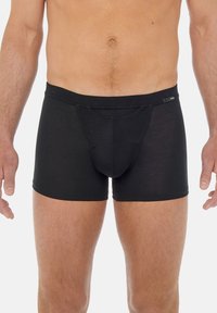 Schwarze Baumwoll-Boxershorts mit einer enganliegendem Design, ausgestattet mit einem glatten Bund und einem konturierten Beutel für zusätzlichen Halt. Matte Stofftextur.