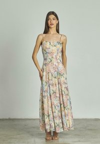 Robe maxi florale avec un corsage ajusté, des bretelles spaghetti réglables et une jupe pleine et fluide dans des couleurs pastel avec des roses et des lilas.