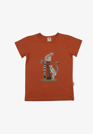 Rust-colored short-sleeve shirt with a design of two ring-tailed lemurs on a tree stump with green grass and a small branch.