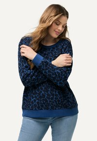 Niebieski sweter w wzór z leopardem, z okrągłym dekoltem, ściągaczami przy mankietach i dole. Wykonany z miękkiej tkaniny; luźny krój z długimi rękawami.