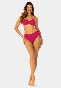 Fuksjowy zestaw bikini z teksturowanym stanikiem na fiszbinach i wysokim stanem majtkami z wiązaniem z boku. Gładki materiał o połyskującym wykończeniu.