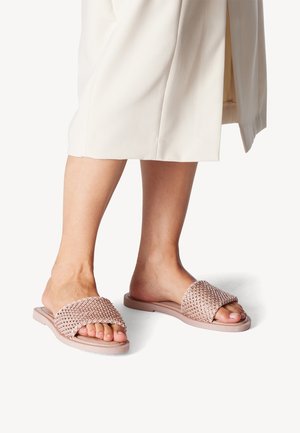 Pink woven slide sandals with a textured crossover strap, flat sole, and open toe, showcasing a casual design in a light color palette.
