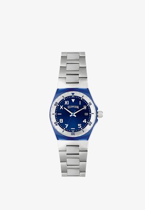 Reloj de acero inoxidable con un dial azul, bisel plateado y acentos azules. Cuenta con una correa metálica de eslabones y marcadores numéricos claros.