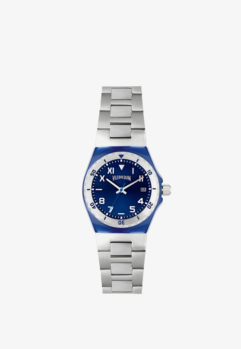 Reloj de acero inoxidable con un dial azul, bisel plateado y acentos azules. Cuenta con una correa metálica de eslabones y marcadores numéricos claros.