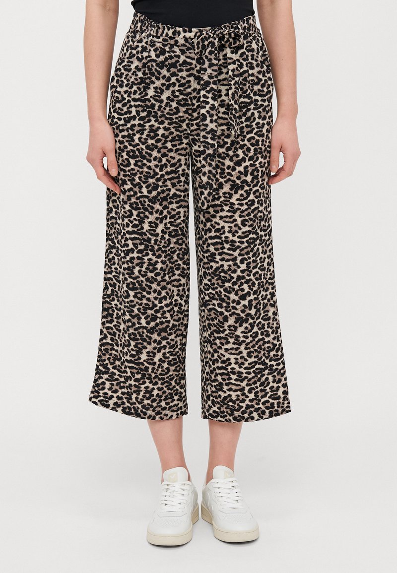 Bredde leggbukser med leopardmønster, med strikk i midjen, myk stoff og overveiende beige med svarte detaljer.