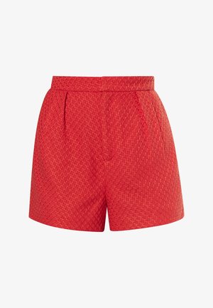 Red woven shorts feature a textured diamond pattern, high waist with pleats, and a smooth finish. No pockets visible.