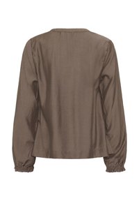 Blouse marron à manches longues avec poignets élastiqués froncés et encolure ronde simple, vue de dos sur un fond blanc.