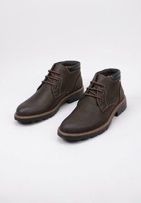 Un par de botas de cuero marrón oscuro hasta el tobillo con cordones, costuras en contraste, cuello acolchado negro y suelas rugosas negras sobre fondo blanco.