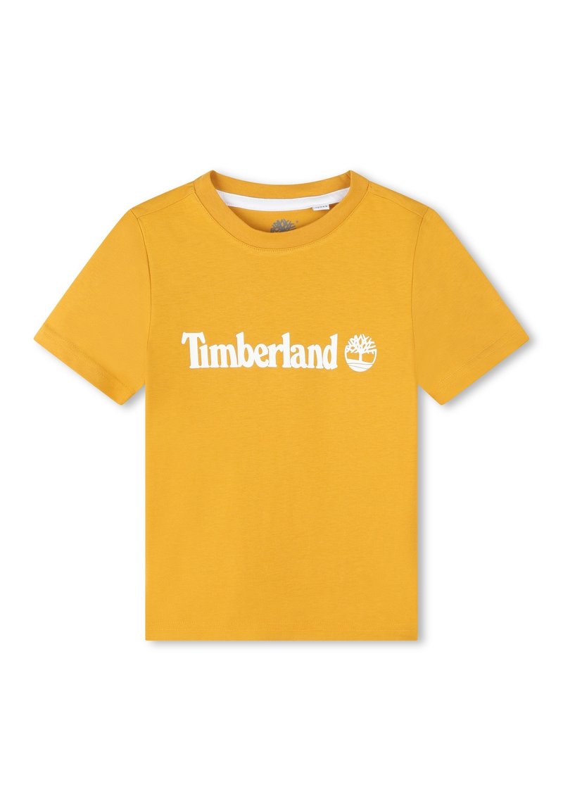 Camiseta de algodón amarilla con mangas cortas y cuello redondo. Presenta un logotipo blanco de "Timberland" y un emblema de árbol en la parte frontal.