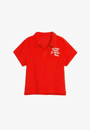 Camiseta polo roja de tela suave, con cuello y mangas cortas. Texto bordado en el pecho izquierdo que dice "buena vida friends club."
