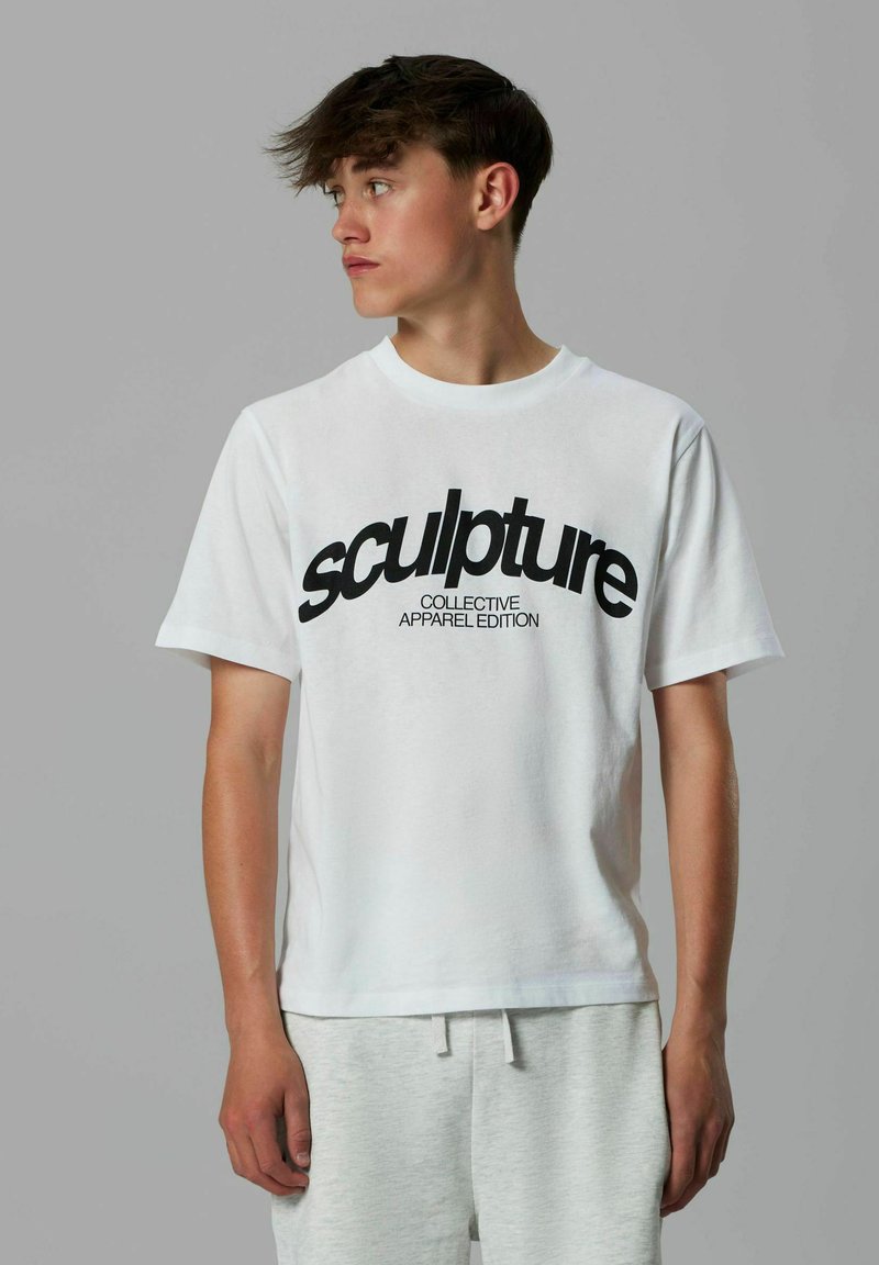 Hvid bomulds T-shirt med en stor sort grafisk tekst "sculpture" og mindre tekst "COLLECTIVE APPAREL EDITION," med korte ærmer.