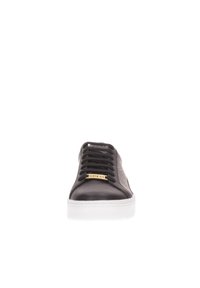 Sneaker in pelle nera con un pannello laterale grigio testurizzato, dettaglio del logo dorato e lacci neri su una suola in gomma bianca. Design classico a basse.